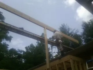 Carpenter setting a ridge beam over a new addition frame — Ice Dam Removal by Roofing Brothers in Mcallen