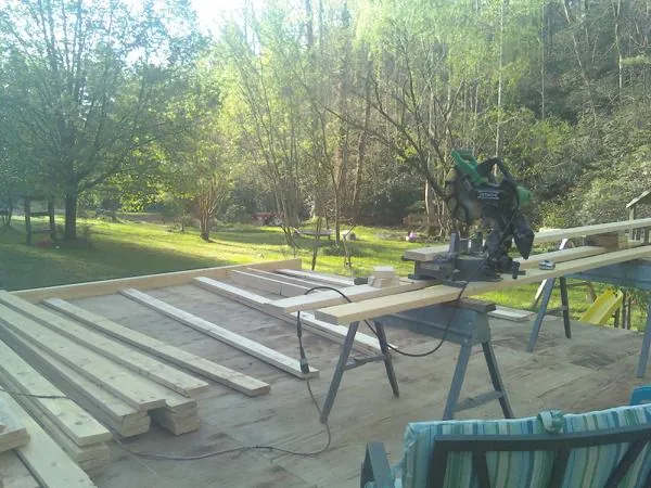 Miter saw and framing lumber on a deck under construction in Mcallen