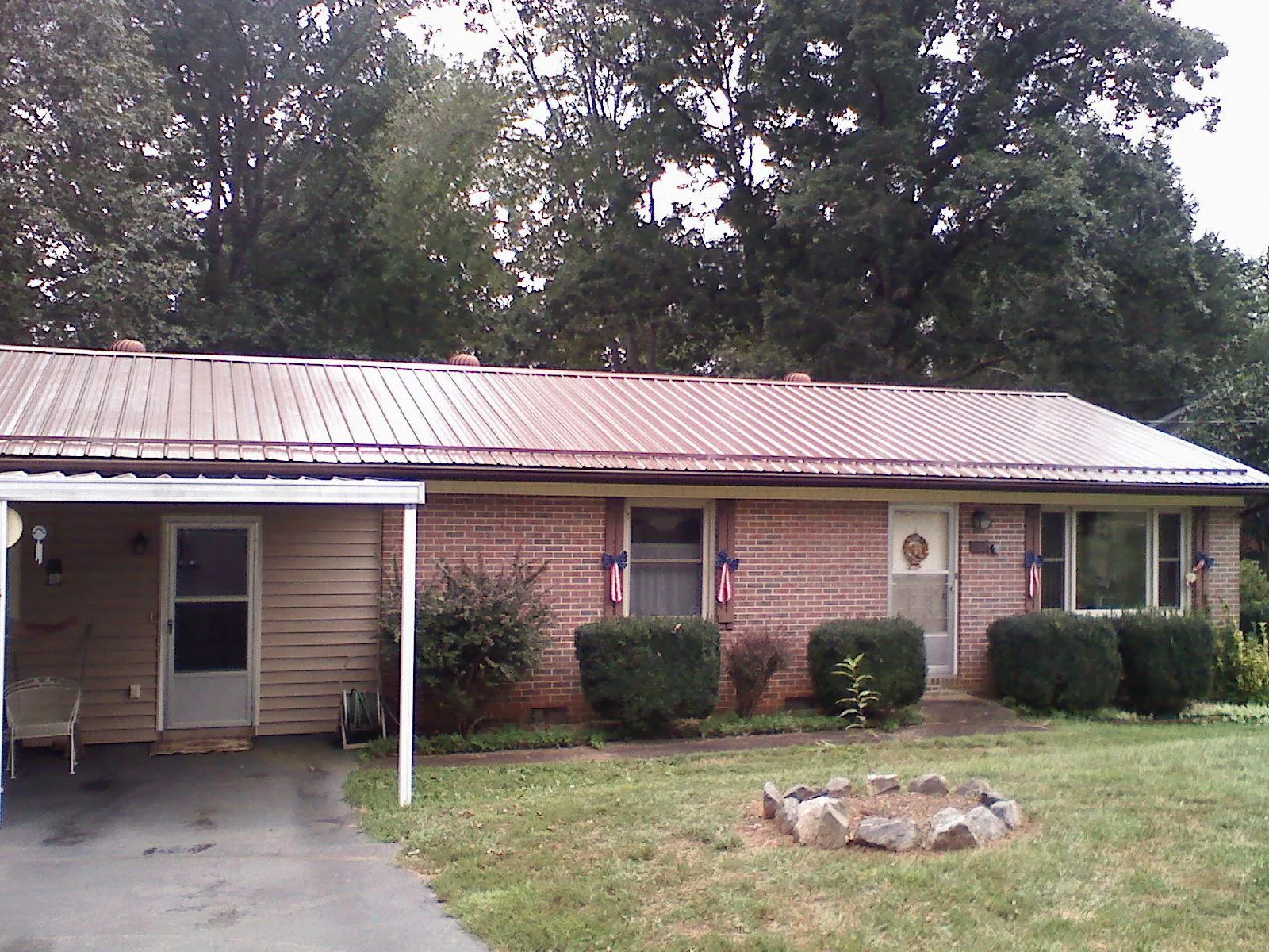 Bronze metal roof and carport on a brick ranch home — Roof Repair work by our crew in Mcallen